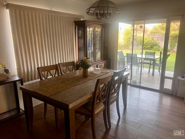 dining space with hardwood / wood-style floors and an inviting chandelier