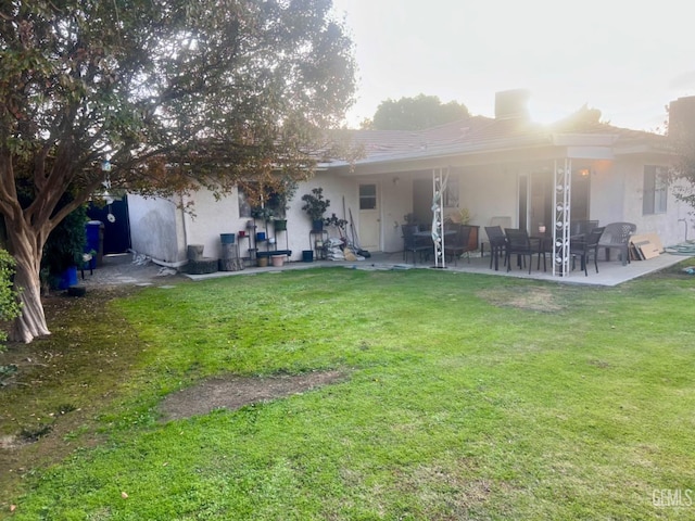 back of house featuring a patio area and a lawn