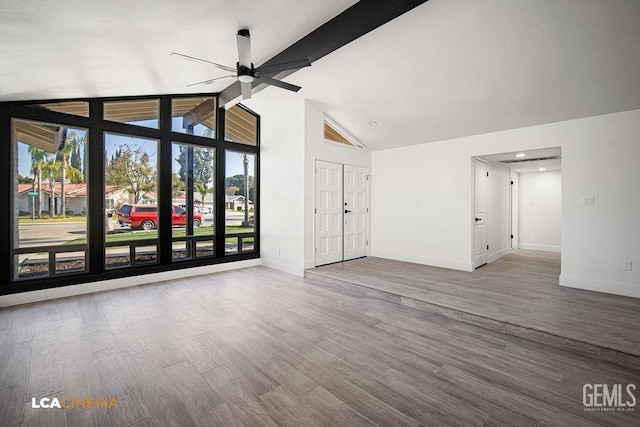 unfurnished living room with lofted ceiling with beams, ceiling fan, and wood-type flooring