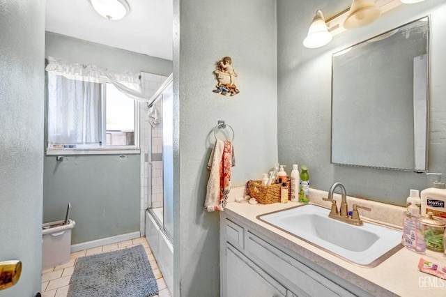 bathroom featuring tile patterned flooring, vanity, and combined bath / shower with glass door