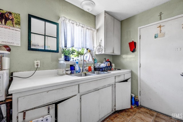 kitchen featuring white cabinetry, sink, and light tile patterned floors