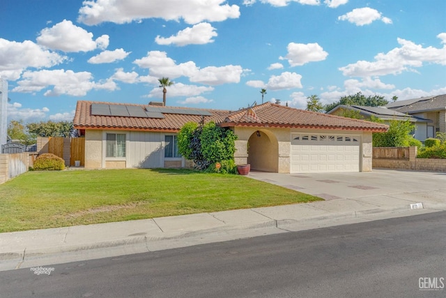 view of front of property featuring a garage, a front yard, and solar panels