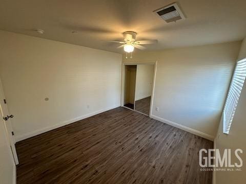 unfurnished bedroom with ceiling fan, dark hardwood / wood-style flooring, and a closet