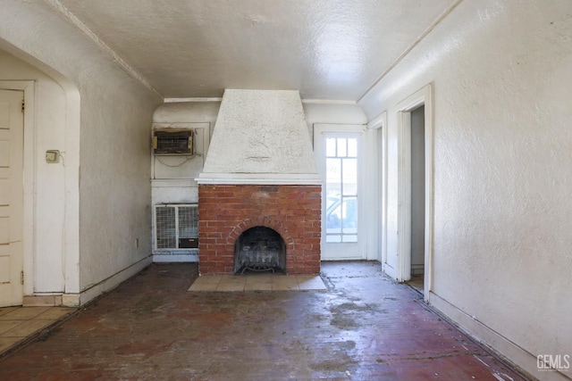 unfurnished living room with a wall mounted AC and a fireplace