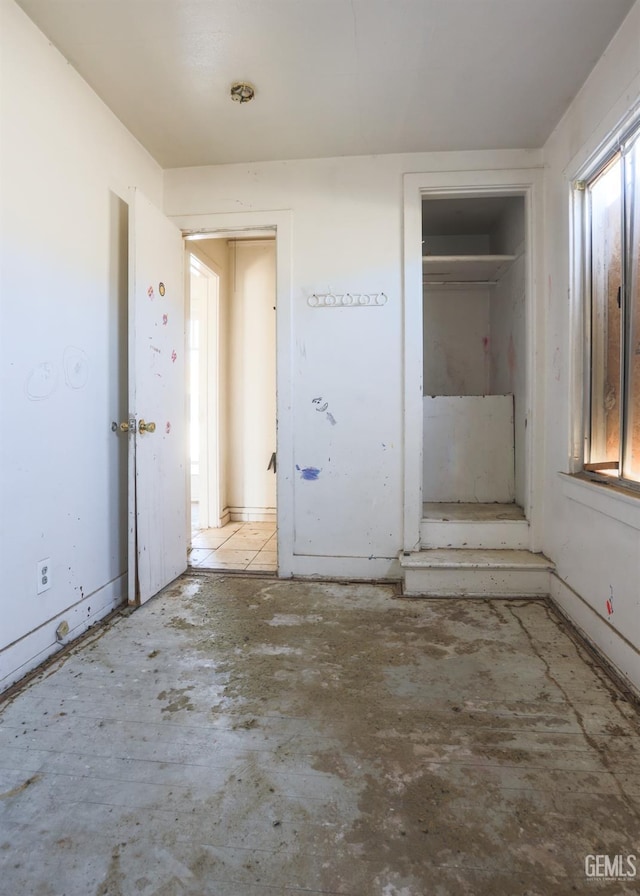 unfurnished bedroom featuring multiple windows and a closet