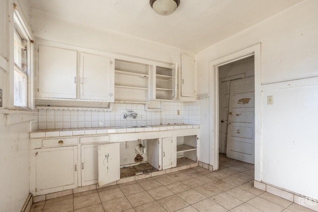 kitchen featuring tile countertops, decorative backsplash, and white cabinets