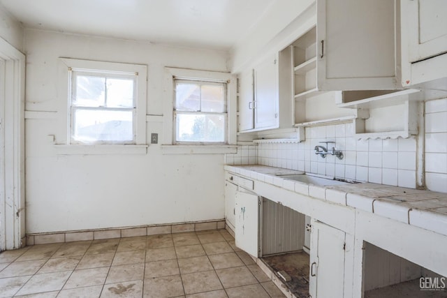 kitchen featuring white cabinets, tile counters, sink, and tasteful backsplash