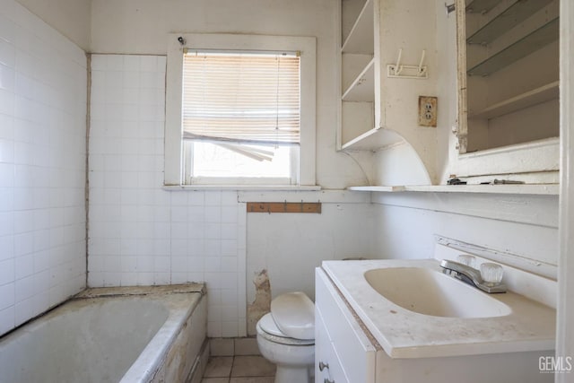 bathroom with a washtub, vanity, tile patterned floors, and toilet