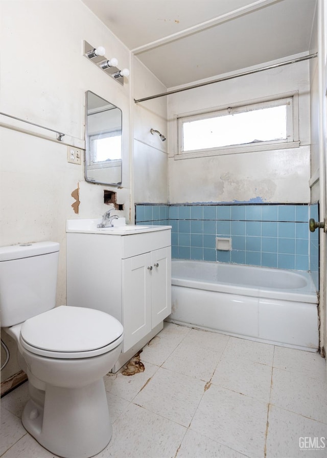 full bathroom with vanity, tiled shower / bath combo, and toilet