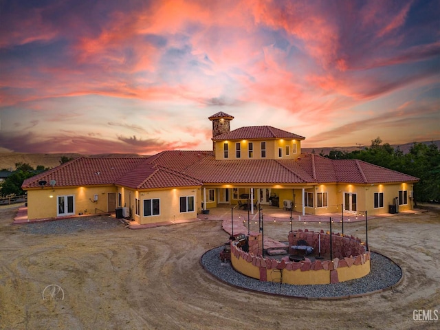 9446 E Kern River Ave, Bakersfield, CA 93308 - rear view of property featuring a tiled roof, stucco siding, a chimney, and a patio