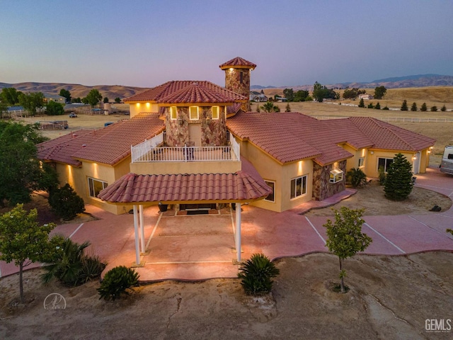 9446 E Kern River Ave, Bakersfield, CA 93308 - rear view of house with a balcony, a tiled roof, a patio area, and stucco siding
