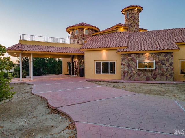 9446 E Kern River Ave, Bakersfield, CA 93308 - back of house featuring a tile roof, stucco siding, and a balcony