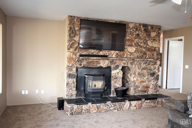 room details featuring carpet flooring, ceiling fan, and a wood stove