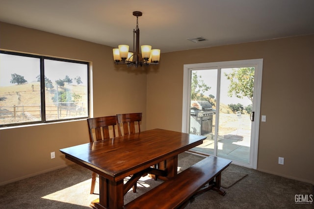 carpeted dining space with an inviting chandelier