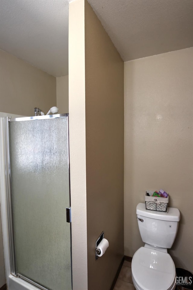 bathroom featuring toilet, tile patterned flooring, a textured ceiling, and walk in shower