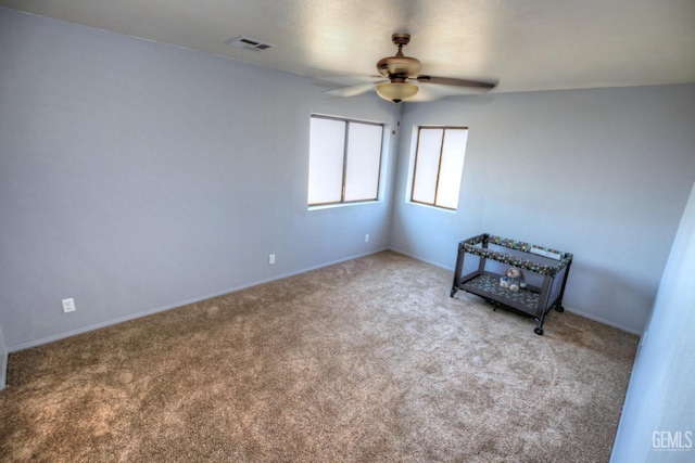 unfurnished room with ceiling fan and light colored carpet