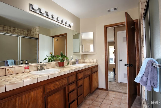 bathroom with tile patterned flooring, vanity, and an enclosed shower