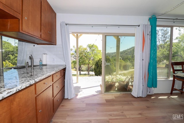 doorway to outside featuring light hardwood / wood-style flooring and sink