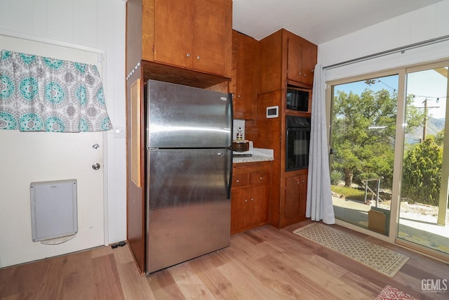 kitchen featuring black appliances and light hardwood / wood-style flooring