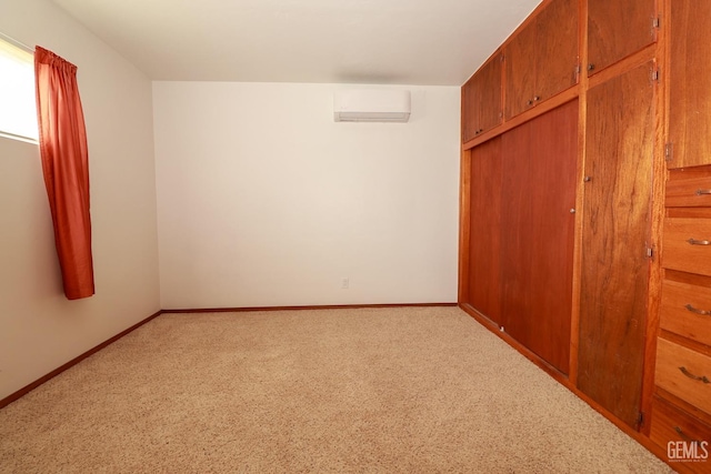 unfurnished bedroom with an AC wall unit, light carpet, and a closet