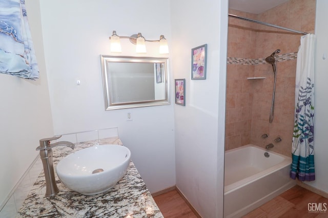 bathroom with vanity, hardwood / wood-style flooring, and shower / tub combo with curtain