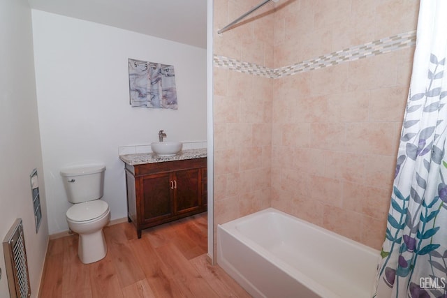 full bathroom with hardwood / wood-style flooring, vanity, toilet, and shower / tub combo