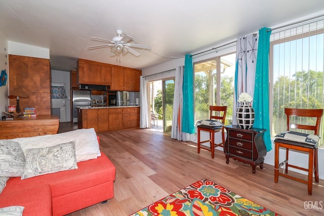 living room with ceiling fan and light hardwood / wood-style flooring