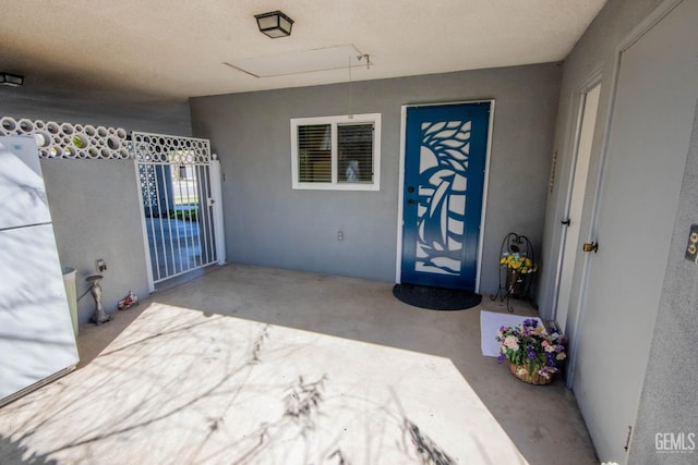 entrance to property featuring stucco siding and a gate