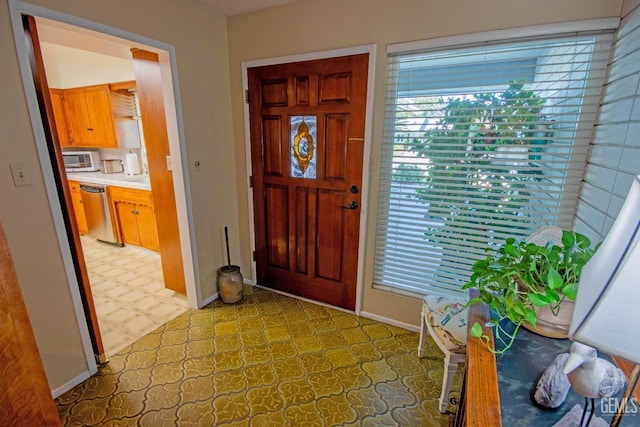 entrance foyer featuring light floors and baseboards