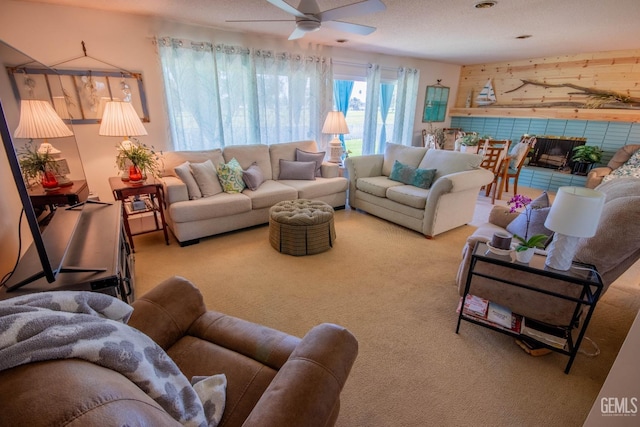 living area featuring a ceiling fan and carpet