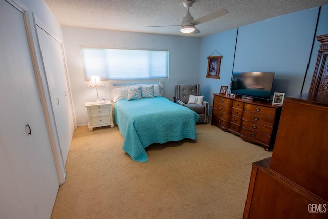 bedroom featuring a ceiling fan, carpet floors, and a textured ceiling