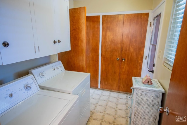 clothes washing area featuring cabinet space, washing machine and dryer, and light floors