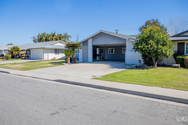 view of front facade with a front yard, a carport, and driveway