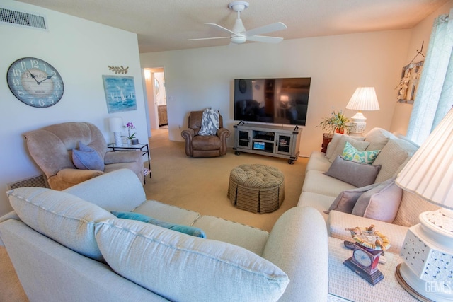 living area featuring visible vents, a ceiling fan, and carpet