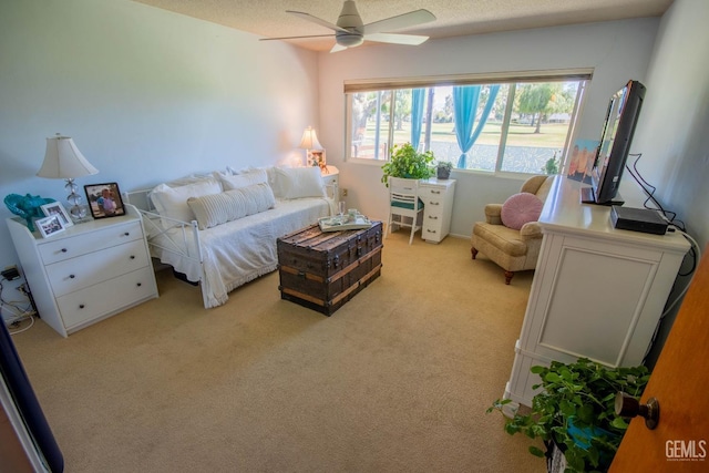 bedroom with light colored carpet, a textured ceiling, and ceiling fan