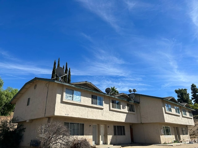 exterior space with cooling unit and stucco siding