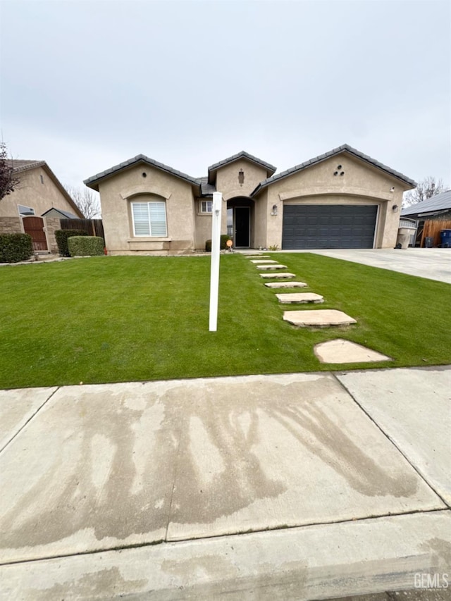 view of front of home with a front yard and a garage