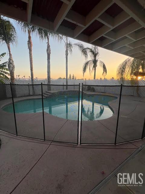 6307 San Rogue Ct, Bakersfield, CA 93312 - pool at dusk featuring a fenced backyard and a patio