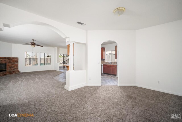 6307 San Rogue Ct, Bakersfield, CA 93312 - unfurnished living room featuring carpet, arched walkways, decorative columns, ceiling fan, and a sink