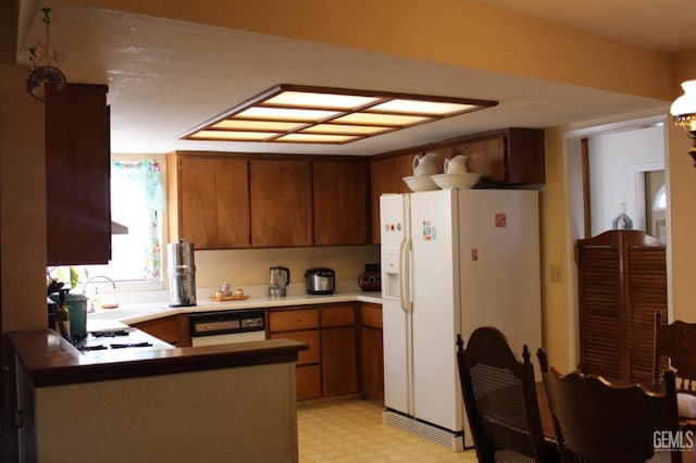 kitchen featuring kitchen peninsula, sink, and white appliances