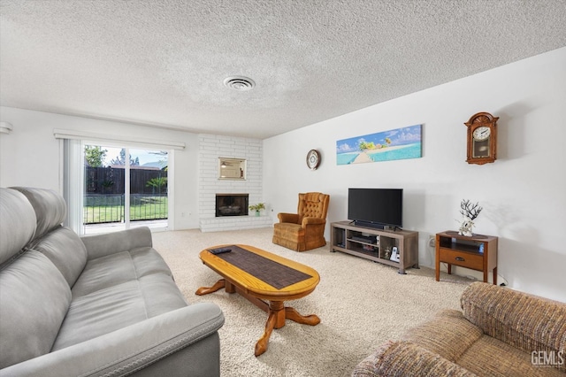 carpeted living area with a textured ceiling, a brick fireplace, and visible vents