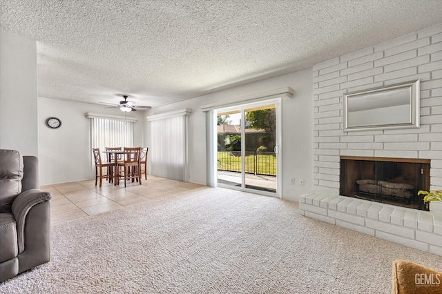 living area featuring a fireplace, light tile patterned flooring, a textured ceiling, and light colored carpet