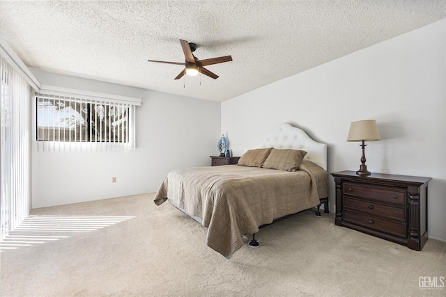 bedroom with a textured ceiling, ceiling fan, and light colored carpet