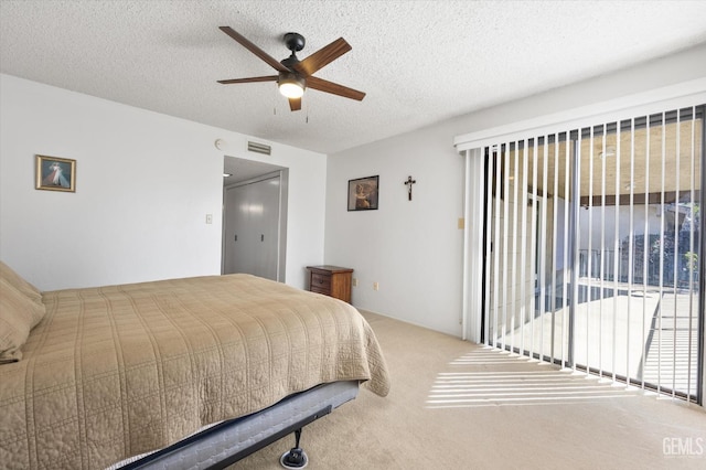 bedroom featuring a textured ceiling, ceiling fan, visible vents, access to exterior, and carpet