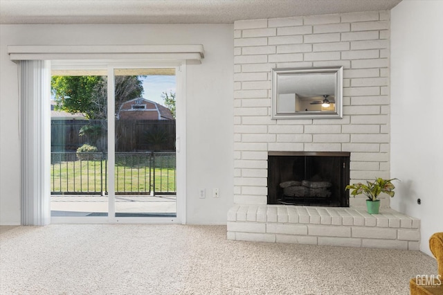 unfurnished living room with carpet, a fireplace, and a textured ceiling