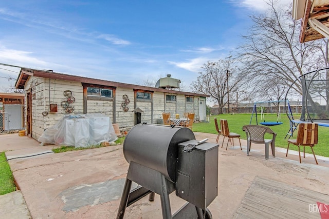 view of patio / terrace with a playground, area for grilling, and a trampoline