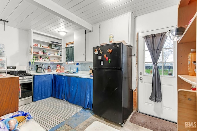 kitchen featuring blue cabinetry, white cabinetry, wooden ceiling, range with gas cooktop, and black refrigerator