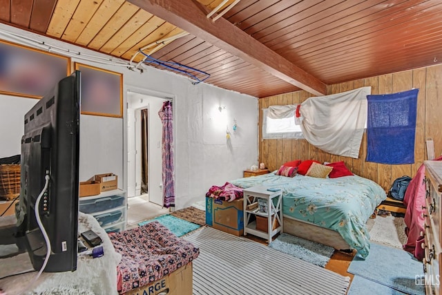 bedroom with beam ceiling and wooden walls