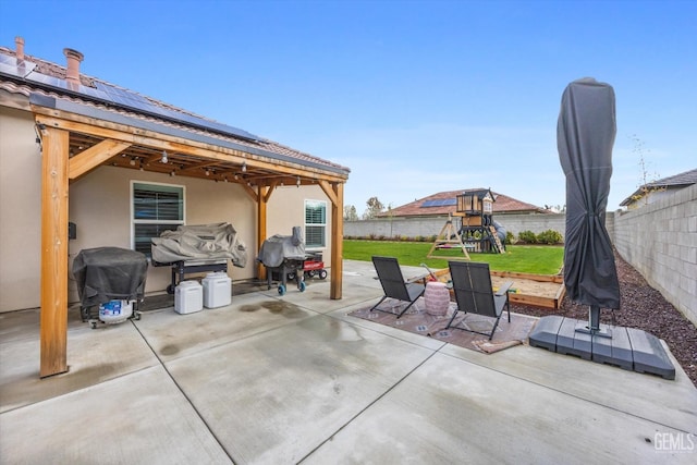 view of patio / terrace featuring a grill, a playground, and a fenced backyard