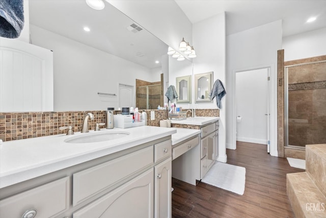 full bathroom featuring a shower stall, visible vents, decorative backsplash, and wood finished floors